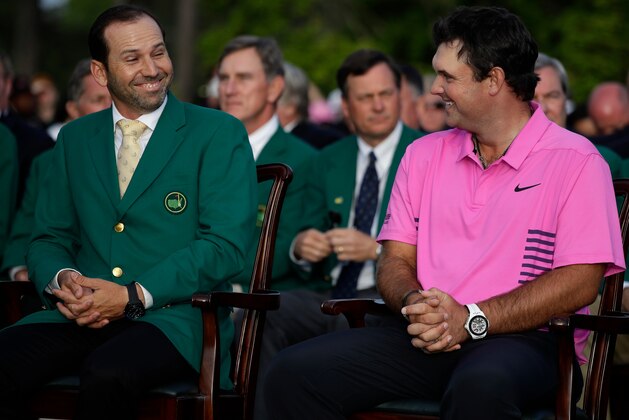Former Masters champion Sergio Garcia, left, of Spain, looks at Patrick Reed's after his win at the Masters golf tournament Sunday, April 8, 2018, in Augusta, Ga. (AP Photo/Chris Carlson)