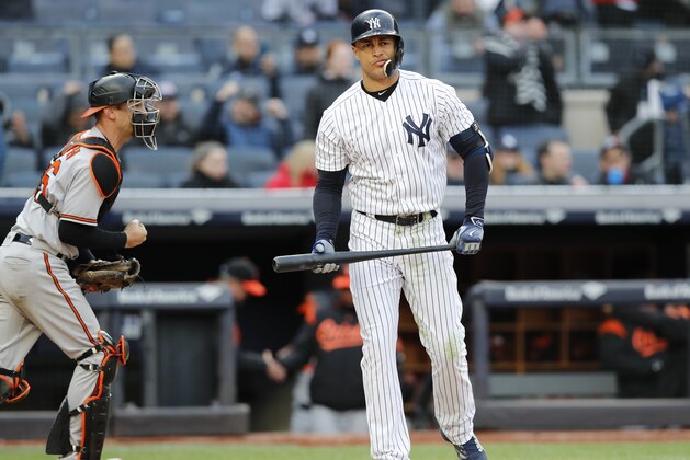 Baltimore Orioles catcher Caleb Joseph, left, and New York Yankees' Giancarlo Stanton react after Stanton stuck out stranding two runners for the final out during the 12th inning of a baseball game in New York, Sunday, April 8, 2018. The Orioles defeated the Yankees 8-7. (AP Photo/Kathy Willens)