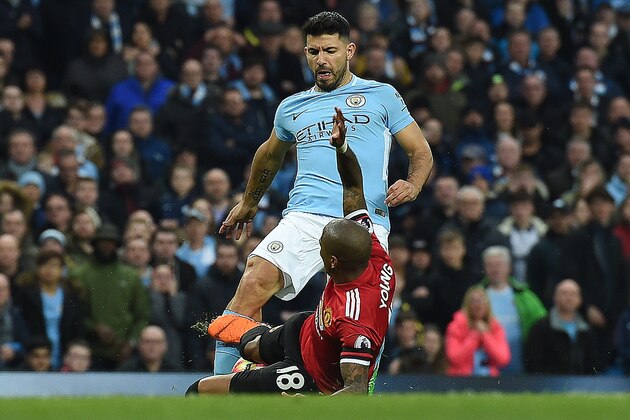 Manchester City's Argentinian striker Sergio Aguero (R) reacts after being tackled by Manchester United's English midfielder Ashley Young during the English Premier League football match between Manchester City and Manchester United at the Etihad Stadium in Manchester, north west England, on April 7, 2018. / AFP PHOTO / PAUL ELLIS / RESTRICTED TO EDITORIAL USE. No use with unauthorized audio, video, data, fixture lists, club/league logos or 'live' services. Online in-match use limited to 75 images, no video emulation. No use in betting, games or single club/league/player publications.  /         (Photo credit should read PAUL ELLIS/AFP/Getty Images)