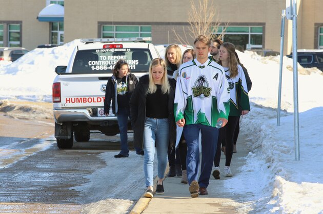People, including a young man wearing a Humboldt Broncos jersey, approach the Uniplex April 8, 2018 in Humboldt, Canada, prior to a memorial vigil for the Humboldt Broncos ice hockey team.  
Mourners in the tiny Canadian town of Humboldt, still struggling to make sense of a devastating tragedy, prepared Sunday for a prayer vigil to honor the victims of the truck-bus crash that killed 15 of their own and shook North American ice hockey.
 / AFP PHOTO / Kymber RAE        (Photo credit should read KYMBER RAE/AFP/Getty Images)
