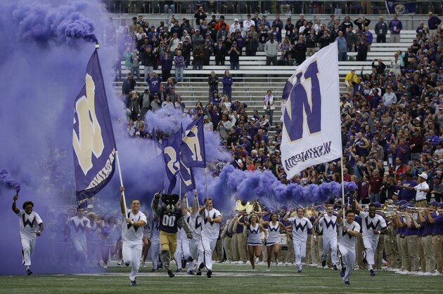 Washington cheerleaders and Harry, the Husky mascot, lead the team out of the tunnel at Husky Stadium for Washington's home opener, an NCAA college football game against Montana, Saturday, Sept. 9, 2017, in Seattle. (AP Photo/Ted S. Warren)