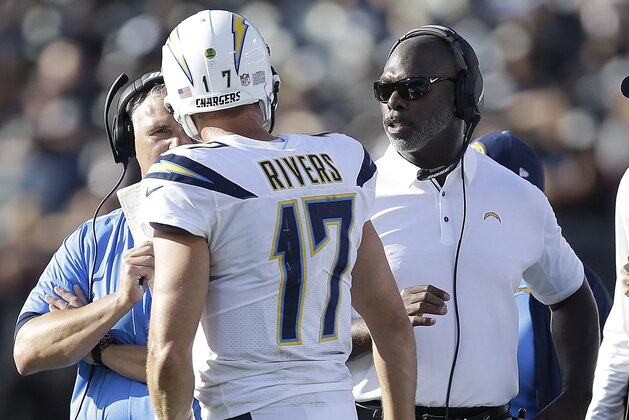 Los Angeles Chargers head coach Anthony Lynn, right, talks to quarterback Philip Rivers (17) during the second half of an NFL football game against the Oakland Raiders in Oakland, Calif., Sunday, Oct. 15, 2017. (AP Photo/Ben Margot)