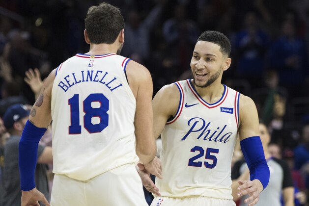 Philadelphia 76ers' Ben Simmons, right, of Australia, reacts to his assist on a three-point basket by Marco Belinelli, left, of Italy, during the first half of an NBA basketball game against the Cleveland Cavaliers, Friday, April 6, 2018, in Philadelphia. (AP Photo/Chris Szagola)
