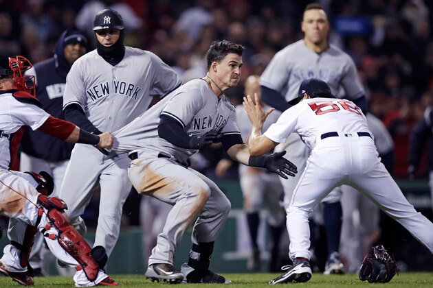 New York Yankees' Tyler Austin, center, rushes Boston Red Sox relief pitcher Joe Kelly, right, after being hit by a pitch during the seventh inning of a baseball game at Fenway Park in Boston, Wednesday, April 11, 2018. At left holding back Austin is Red Sox catcher Christian Vazquez. (AP Photo/Charles Krupa)