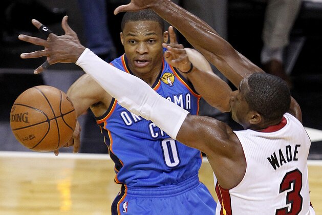 Oklahoma City Thunder point guard Russell Westbrook (0) passes against Miami Heat shooting guard Dwyane Wade (3) during the second half at Game 3 of the NBA Finals basketball series, Sunday, June 17, 2012, in Miami. (AP Photo/Wilfredo Lee)