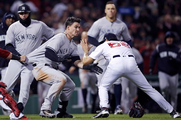 New York Yankees' Tyler Austin, center, rushes Boston Red Sox relief pitcher Joe Kelly, right, after being hit by a pitch during the seventh inning of a baseball game at Fenway Park in Boston, Wednesday, April 11, 2018. At left holding back Austin is Red Sox catcher Christian Vazquez. (AP Photo/Charles Krupa)