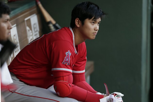 Los Angeles Angels' Shohei Ohtani sits in the dugout in the first inning of a baseball game against the Texas Rangers in Arlington, Texas, Wednesday April 11, 2018. (AP Photo/Tony Gutierrez)