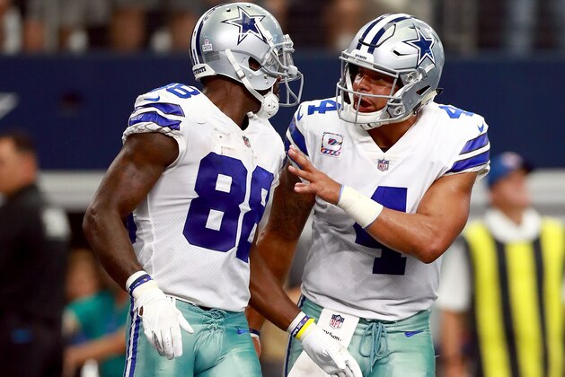 ARLINGTON, TX - OCTOBER 08:  Dak Prescott #4 of the Dallas Cowboys celebrates after throwing a touchdown pass to Dez Bryant #88 of the Dallas Cowboys to score against the Green Bay Packers in the second quarter at AT&T Stadium on October 8, 2017 in Arlington, Texas.  (Photo by Tom Pennington/Getty Images)