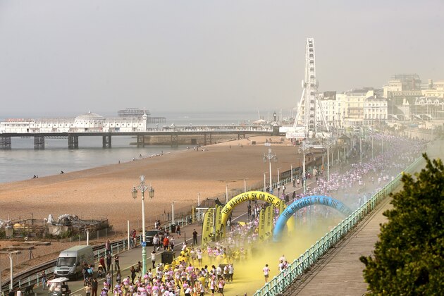 BRIGHTON, ENGLAND - SEPTEMBER 20:  A general view of the Color Run presented by Dulux, known as the happiest 5km on the planet on September 20, 2014 in Brighton, England. Runners of all shapes, sizes and speeds start wearing white clothing. At each kilometre a different colour of powder is thrown in the air with the runners becoming a constantly evolving artwork. At the end of the course runners are greeted by the Color Festival where the air is filled with music and stunning coloured powder bursts creating a vibrant party atmosphere.  (Photo by Jordan Mansfield/Getty Images for Dulux)