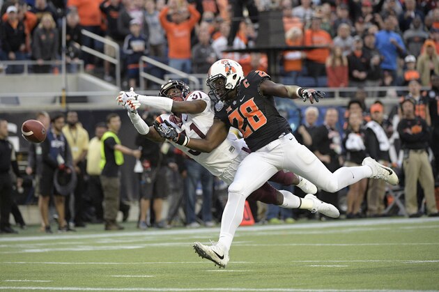 Virginia Tech cornerback Brandon Facyson (31) breaks up a pass intended for Oklahoma State wide receiver James Washington (28) during the first half of the Camping World Bowl NCAA college football game Thursday, Dec. 28, 2017, in Orlando, Fla. (AP Photo/Phelan M. Ebenhack)