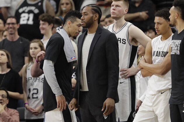 San Antonio Spurs forward Kawhi Leonard, center, waiting to return from injury, wears street cloths as he watches from the bench during the second half of an NBA basketball game against the New Orleans Pelicans, Wednesday, Feb. 28, 2018, in San Antonio. New Orleans won 121-116. (AP Photo/Eric Gay)