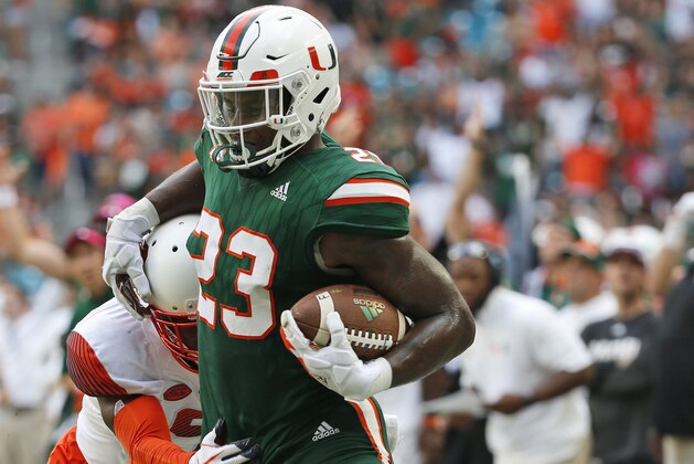 Miami tight end Christopher Herndon IV (23) is pushed out of bounds by Syracuse defensive back Juwan Dowels during the first half of an NCAA College football game, Saturday, Oct. 21, 2017 in Miami Gardens, Fla. (AP Photo/Wilfredo Lee)