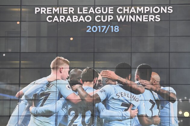 A new poster showing members of the Manchester City team celebrating has been placed at the entrance to the Etihad Stadium in Manchester, north west England to celebrate Manchester City winning the Premier League title on April 16, 2018.
Pep Guardiola's side were crowned kings of English football yesterday as their arch rivals Manchester United slumped to a shock 1-0 defeat against struggling West Bromwich Albion. / AFP PHOTO / Paul ELLIS / RESTRICTED TO EDITORIAL USE. No use with unauthorized audio, video, data, fixture lists, club/league logos or 'live' services. Online in-match use limited to 75 images, no video emulation. No use in betting, games or single club/league/player publications.  /         (Photo credit should read PAUL ELLIS/AFP/Getty Images)
