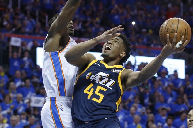 Utah Jazz guard Donovan Mitchell (45) shoots as Oklahoma City Thunder forward Jerami Grant, left, defends in the second half of Game 1 of an NBA basketball first-round playoff series in Oklahoma City, Sunday, April 15, 2018. (AP Photo/Sue Ogrocki)