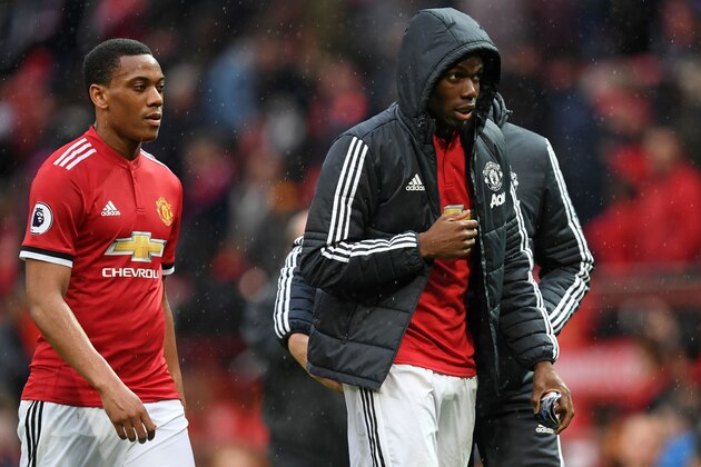 Manchester United's French striker Anthony Martial (L) and Manchester United's French midfielder Paul Pogba leave the field after the English Premier League football match between Manchester United and West Bomwich Albion at Old Trafford in Manchester, north west England, on April 15, 2018.
Manchester City were crowned Premier League champions on Sunday as Manchester United crashed to a shock 1-0 defeat against West Bromwich Albion. / AFP PHOTO / Paul ELLIS / RESTRICTED TO EDITORIAL USE. No use with unauthorized audio, video, data, fixture lists, club/league logos or 'live' services. Online in-match use limited to 75 images, no video emulation. No use in betting, games or single club/league/player publications.  /         (Photo credit should read PAUL ELLIS/AFP/Getty Images)