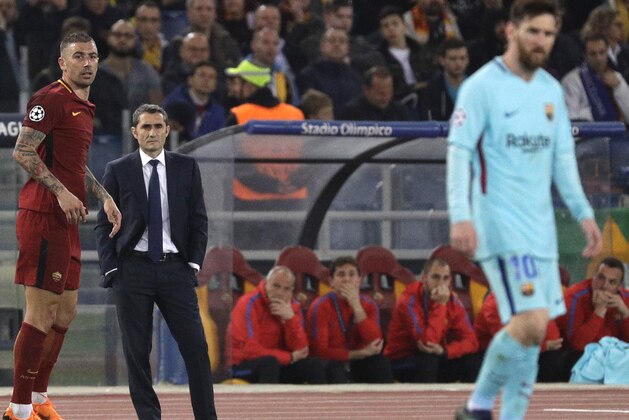 Barcelona coach Ernesto Valverde, second left, watches his players as Roma's Juan Jesus, left, and Barcelona's Lionel Messi, right, wait for the game to resume during the Champions League quarterfinal second leg soccer match between between Roma and FC Barcelona, at Rome's Olympic Stadium, Tuesday, April 10, 2018. (AP Photo/Gregorio Borgia)