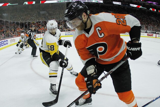 Philadelphia Flyers' Claude Giroux, right, gains control of the puck from Pittsburgh Penguins' Kris Letang, left, during the second period in Game 3 of an NHL first-round hockey playoff series Sunday, April 15, 2018, in Philadelphia, Pa. The Penguins won 5-1. (AP Photo/Tom Mihalek)