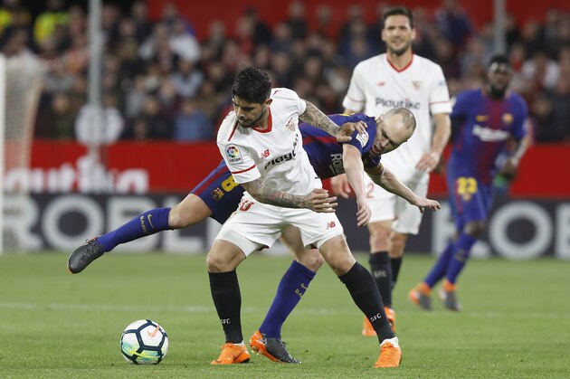 Barcelona's Andres Iniesta, behind, and Sevilla's Banega fight for the ball Sevilla during La Liga soccer match between Barcelona and Sevilla at the Sanchez Pizjuan stadium, in Seville, Spain on Saturday, March 31, 2018. (AP Photo/Miguel Morenatti)