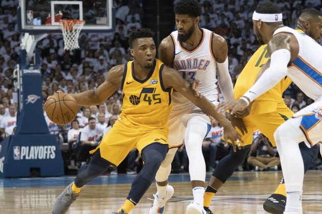 OKLAHOMA CITY, OK - APRIL 18:  Donovan Mitchell #45 of the Utah Jazz battles his way around Paul George #13 of the Oklahoma City Thunder during the first half of Game 2 of the Western Conference playoffs at the Chesapeake Energy Arena on April 18, 2018 in Oklahoma City, Oklahoma. NOTE TO USER: User expressly acknowledges and agrees that, by downloading and or using this photograph, User is consenting to the terms and conditions of the Getty Images License Agreement. (Photo by J Pat Carter/Getty Images)