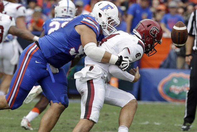 Florida defensive lineman Taven Bryan, left, forces a fumble as he tackles South Carolina quarterback Jake Bentley, right, during the first half of an NCAA college football game, Saturday, Nov. 12, 2016, in Gainesville, Fla. (AP Photo/John Raoux)
