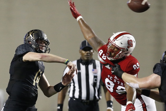 Vanderbilt quarterback Kyle Shurmur (14) is pressured into throwing an incomplete pass by North Carolina State defensive tackle B.J. Hill (98) in the second half of the Camping World Independence Bowl NCAA college football game in Shreveport, La., Monday, Dec. 26, 2016. North Carolina State won 41-17.(AP Photo/Rogelio V. Solis)