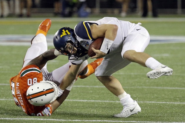 Miami defensive lineman RJ McIntosh (80) sacks West Virginia quarterback Skyler Howard during the second half of the Russell Athletic Bowl NCAA college football game, Wednesday, Dec. 28, 2016, in Orlando, Fla. Miami won 31-14. (AP Photo/John Raoux)