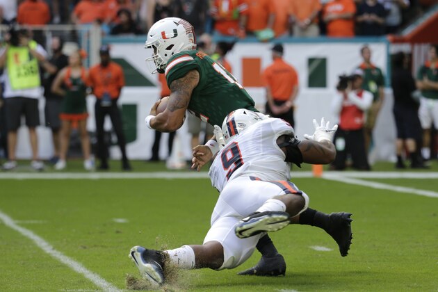 Miami quarterback Malik Rosier (12) avoids a tackle by Virginia defensive end Andrew Brown (9) during the first half of an NCAA college football game, Saturday, Nov. 18, 2017, in Miami Gardens, Fla. (AP Photo/Lynne Sladky)