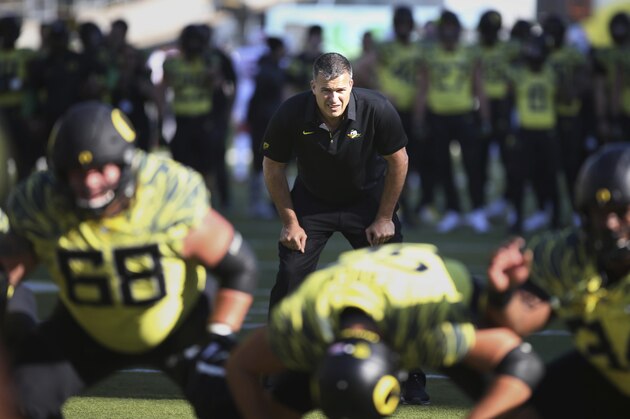 FILE - In this Oct. 28, 2017, file photo, Oregon co-offensive coordinator Mario Cristobal watches a special team warmup drill before an NCAA college football game against Utah, in Eugene, Ore. A person with direct knowledge of the situation says Oregon will hire Mario Cristobal as its head coach. The person spoke to The Associated Press on condition of anonymity because a deal and announcement were still being finalized. Cristobal was offensive coordinator at Oregon this past season and was named interim coach on Tuesday, Dec. 5, 2017, when Willie Taggart left to become coach at Florida State. (AP Photo/Chris Pietsch, File)