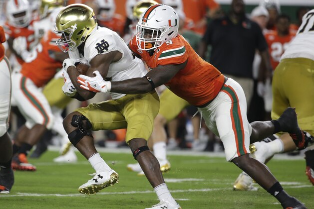 Notre Dame running back Josh Adams, left, is tackled by Miami defensive lineman Chad Thomas during the first half of an NCAA college football game, Saturday, Nov. 11, 2017, in Miami Gardens, Fla. (AP Photo/Lynne Sladky)