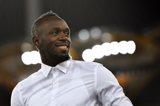 Jamaica's former sprinter Usain Bolt is seen during the athletics women's 200m medal ceremony during the 2018 Gold Coast Commonwealth Games at the Carrara Stadium on the Gold Coast on April 12, 2018. / AFP PHOTO / SAEED KHAN        (Photo credit should read SAEED KHAN/AFP/Getty Images)