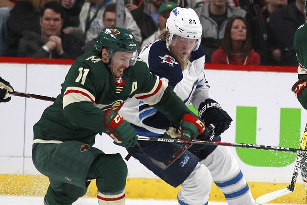 Minnesota Wild left wing Zach Parise (11) battles with Winnipeg Jets right wing Patrik Laine (29) in the first period of Game 3 of an NHL first-round hockey playoff series Sunday, April 15, 2018, in St. Paul, Minn. The Wild won the game 6-2 but trail the Jets 2-1 in the series. (AP Photo/Andy Clayton-King)