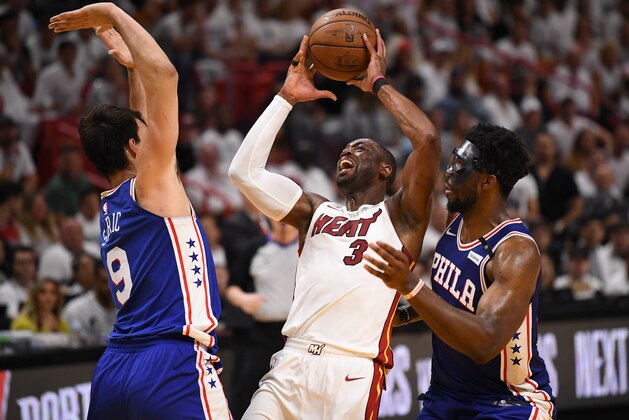 MIAMI, FL - APRIL 21: Dwyane Wade #3 of the Miami Heat attempts to drive to the basket as he is surrounded by Dario Saric #9 and Joel Embiid #21 of the Philadelphia 76ers in the fourth quarter during Game Four of Round One of the 2018 NBA Playoffs at American Airlines Arena on April 21, 2018 in Miami, Florida. NOTE TO USER: User expressly acknowledges and agrees that, by downloading and or using this photograph, User is consenting to the terms and conditions of the Getty Images License Agreement. (Photo by Mark Brown/Getty Images)