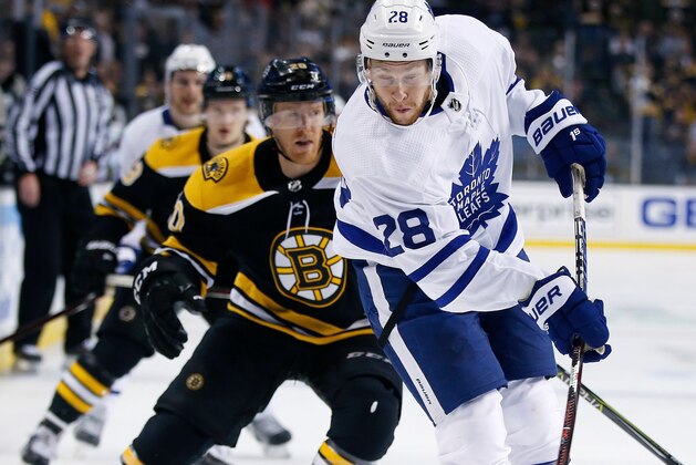 Toronto Maple Leafs' Connor Brown (28) takes a shot in front of Boston Bruins' Riley Nash (20) during the third period of Game 5 of an NHL hockey first-round playoff series in Boston, Saturday, April 21, 2018. The Maple Leafs won 4-3. (AP Photo/Michael Dwyer)