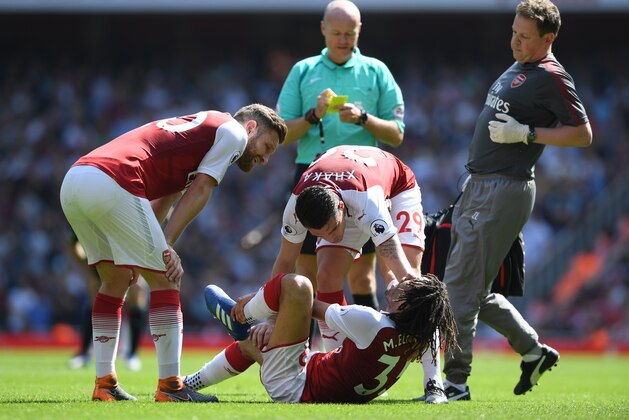 LONDON, ENGLAND - APRIL 22:  Granit Xhaka checks if Mohamed Elneny of Arsenal is ok as the medical team arrive on pitch during the Premier League match between Arsenal and West Ham United at Emirates Stadium on April 22, 2018 in London, England.  (Photo by Shaun Botterill/Getty Images)