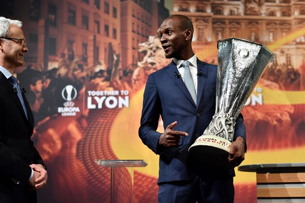 UEFA Deputy General Secretary Giorgio Marchetti Giorgio Marchetti (L) and former French football player and ambassador for the UEFA Europa League final in Lyon, Eric Abidal share a light moment during the handover of the trophy following the draw for the semi-finals round of the UEFA Europa League football tournament at the UEFA headquarters in Nyon on April 13, 2018.  / AFP PHOTO / Fabrice COFFRINI        (Photo credit should read FABRICE COFFRINI/AFP/Getty Images)