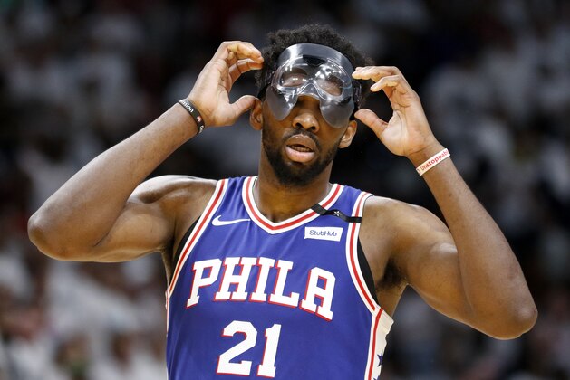 Philadelphia 76ers center Joel Embiid (21) adjusts his mask in the third quarter of play against the Miami Heat in Game 4 of a first-round NBA basketball playoff series, Saturday, April 21, 2018, in Miami. (AP Photo/Joe Skipper)
