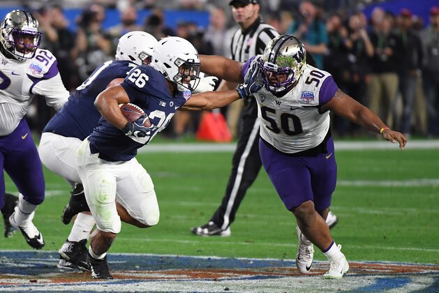 GLENDALE, AZ - DECEMBER 30:  Saquon Barkley #26 of Penn State Nittany Lions runs with the ball while straight arming Vita Vea #50 of the Washington Huskies during the Playstation Fiesta Bowl at University of Phoenix Stadium on December 30, 2017 in Glendale, Arizona.  (Photo by Norm Hall/Getty Images)
