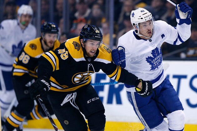 Boston Bruins' Matt Grzelcyk (48) battles Toronto Maple Leafs' Tyler Bozak (42) during the first period of Game 5 of an NHL hockey first-round playoff series in Boston, Saturday, April 21, 2018. The Maple Leafs won 4-3. (AP Photo/Michael Dwyer)