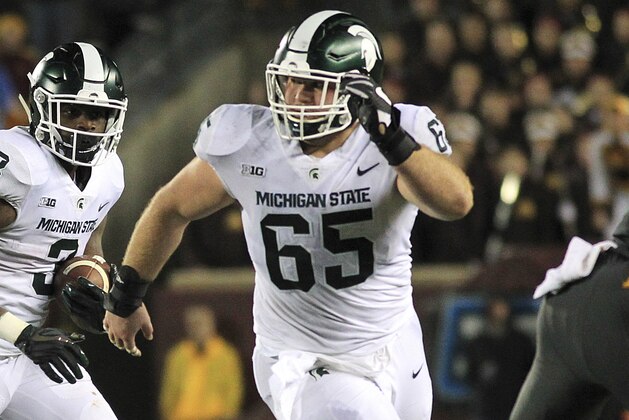 Michigan State running back L.J. Scott (3) runs with blocking from teammate guard Brian Allen (65) against Minnesota in the third quarter of an NCAA college football game Saturday, Oct. 14, 2017, in Minneapolis. Michigan State defeated Minnesota 30-27. (AP Photo/Andy Clayton-King)