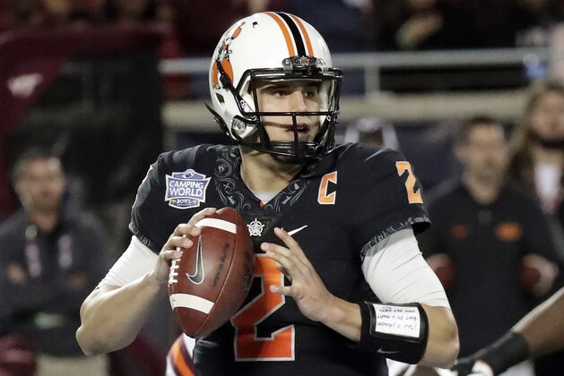 Oklahoma State quarterback Mason Rudolph looks for a receiver against Virginia Tech during the second half of the Camping World Bowl NCAA college football game, Thursday, Dec. 28, 2017, in Orlando, Fla. Oklahoma State won 30-21.(AP Photo/John Raoux)