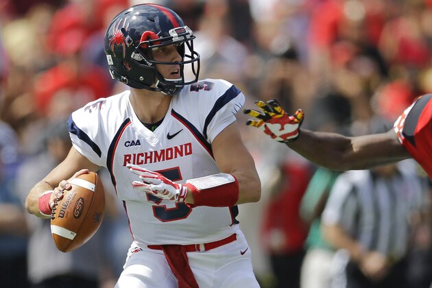 Richmond quarterback Kyle Lauletta, left, looks for a receiver as he is pressured by Maryland defensive lineman Jesse Aniebonam in the first half of an NCAA college football game, Saturday, Sept. 5, 2015, in College Park, Md. (AP Photo/Patrick Semansky)