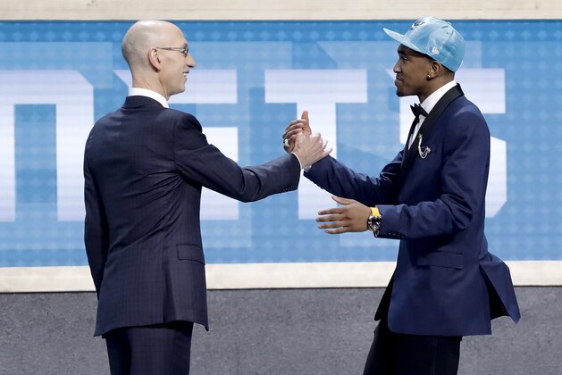 Kentucky's Malik Monk, right, is greeted by NBA Commissioner Adam Silver after being selected by the Charlotte Hornets as the 11th pick overall during the NBA basketball draft, Thursday, June 22, 2017, in New York. (AP Photo/Frank Franklin II)