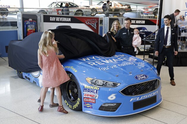 NASCAR driver Matt Kenseth, center, gets helps from his family as they unveil the car he will drive this season during a news conference in Charlotte, N.C., Wednesday, April 25, 2018. Kenseth will return to NASCAR this season in a reunion with Roush Fenway Racing, the team that gave him his Cup start in 1998. Kenseth will split the No. 6 Ford with Trevor Bayne, who has been the full-time driver of that car since 2015. (AP Photo/Chuck Burton)