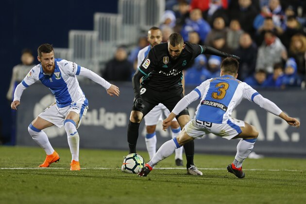 Real Madrid's Karim Benzema, center, vies for the ball with Leganes' Unai Bustinza, right, during a Spanish La Liga soccer match between Real Madrid and Leganes at the Butarque stadium in Leganes, outside Madrid, Wednesday, Feb. 21, 2018. (AP Photo/Francisco Seco)