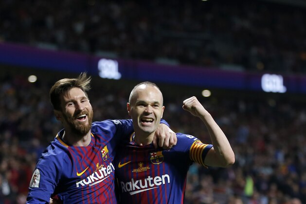 Barcelona's Andres Iniesta, right, celebrates withLionel Messi after scoring his side's fourth goal during the Copa del Rey final soccer match between Barcelona and Sevilla at the Wanda Metropolitano stadium in Madrid, Spain, Saturday, April 21, 2018. (AP Photo/Paul White)