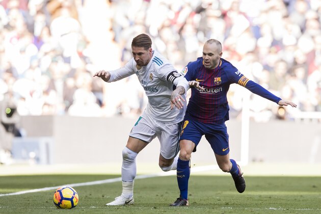 MADRID, SPAIN - DECEMBER 23: Sergio Ramos (L) of Real Madrid fights for the ball with Andres Iniesta Lujan of FC Barcelona during the La Liga 2017-18 match between Real Madrid and FC Barcelona at Santiago Bernabeu Stadium on December 23 2017 in Madrid, Spain. (Photo by Power Sport Images/Getty Images)