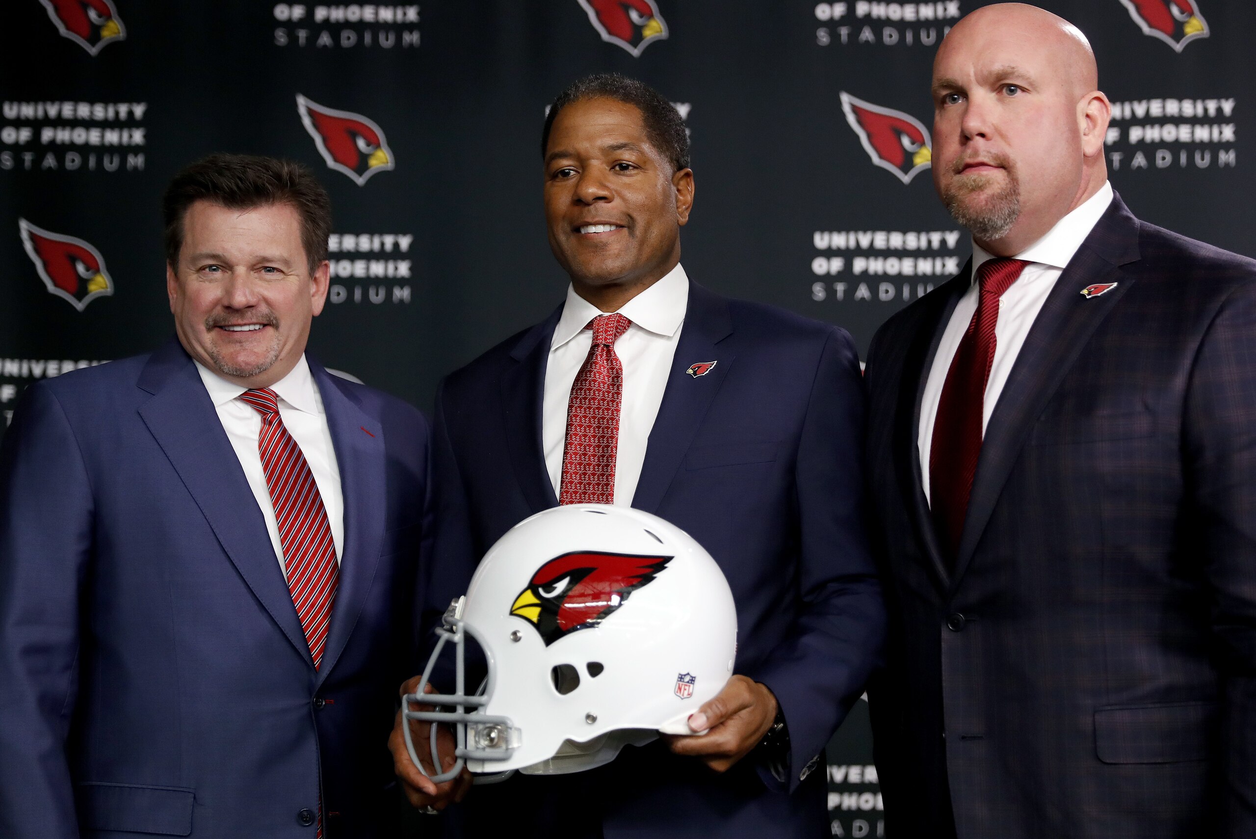 Newly appointed Arizona Cardinals football head coach Steve Wilks, center, poses for photographers with general manager Steve Keim, right, and team president Michael Bidwill, Tuesday, Jan. 23, 2018, after being introduced at the teams' training facility in Tempe, Ariz. (AP Photo/Matt York)