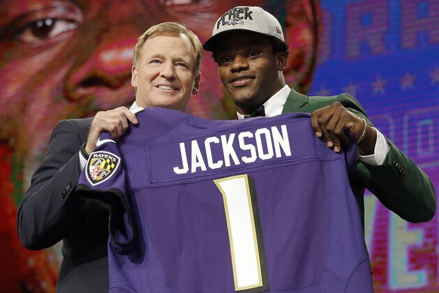 Commissioner Roger Goodell, left, presents Louisville's Lamar Jackson with his Baltimore Ravens jersey during the first round of the NFL football draft, Thursday, April 26, 2018, in Arlington, Texas. (AP Photo/David J. Phillip)