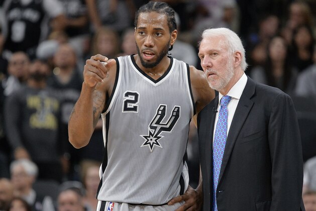 San Antonio Spurs forward Kawhi Leonard (2) talks with head coach Gregg Popovich during the second half of an NBA basketball game against the Oklahoma City Thunder, Saturday, March 12, 2016, in San Antonio. San Antonio won 93-85. (AP Photo/Darren Abate)