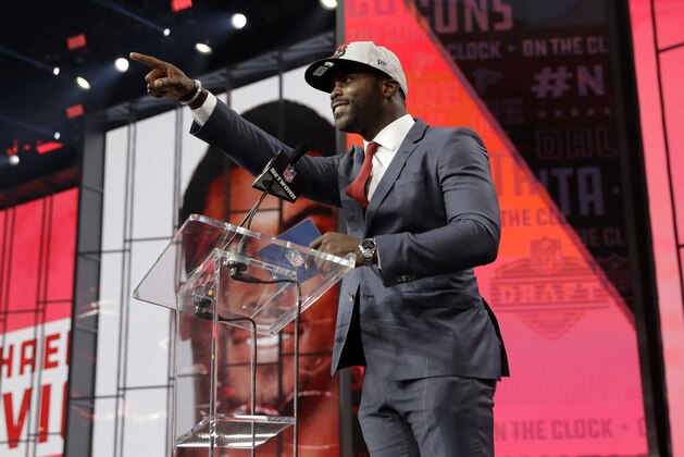 Former Atlanta Falcons player Michael Vick gestures to Falcons fans as he announces Colorado's Isaiah Oliver as the team's pick during the second round of the NFL football draft Friday, April 27, 2018, in Arlington, Texas. (AP Photo/Eric Gay)
